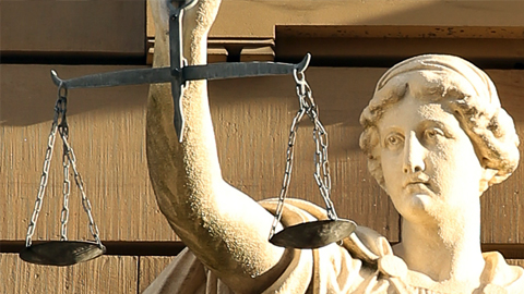 Statue einer Justitia mit Waage. (Link zu: Psychosoziale Prozessbegleitung)